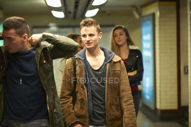 Quatre jeunes amis adultes marchant à travers la station de métro de Londres, Londres, Royaume-Uni — Photo de stock
