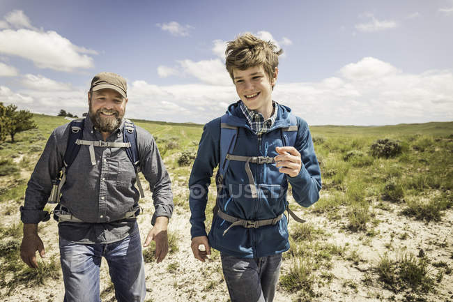 Father and teenage son racing each other on hiking trip, Cody, Wyoming, USA — Stock Photo