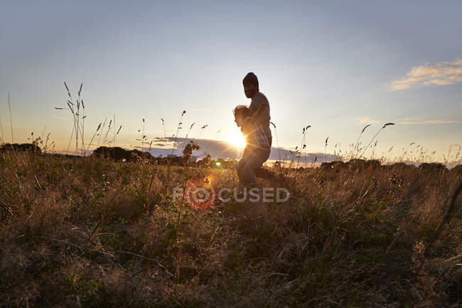 Padre e figlio che camminano nel parco soleggiato — Foto stock