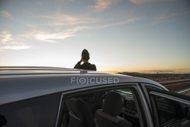 Задній вид силуетними жінка, спостерігаючи захід сонця, пустелі Мохаве, Каліфорнія, США — стокове фото