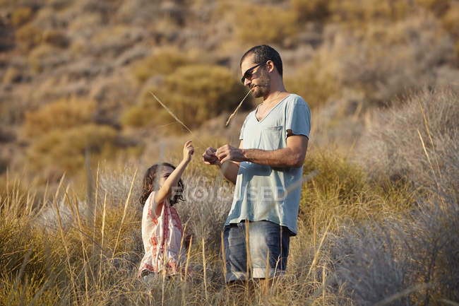 Pai e filha brincando com grama longa, Almeria, Andaluzia, Espanha — Fotografia de Stock