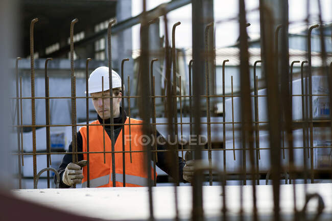 Работник завода выбирает сетку из проволоки на бетонном заводе — стоковое фото
