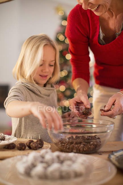 Mother and daughter baking chocolate truffles at home in Christmas — Stock Photo