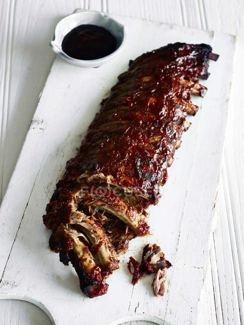 Rack of pork ribs on wooden cutting board — Stock Photo
