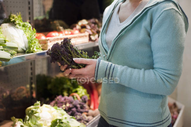 Imagen recortada de la mujer de compras y la elección de verduras - foto de stock