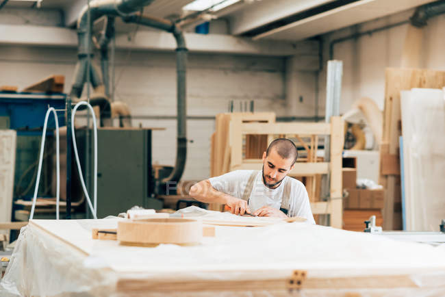 Young adult carpenter at work in workshop — Stock Photo