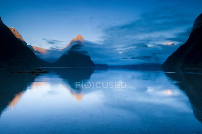 Montanhas rurais refletidas em lago imóvel — Fotografia de Stock