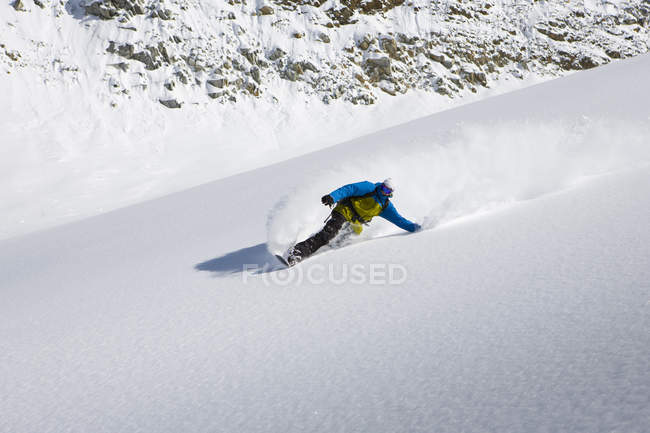 Snowboarder maschio snowboard giù ripida montagna, Trento, Alpi svizzere, Svizzera — Foto stock