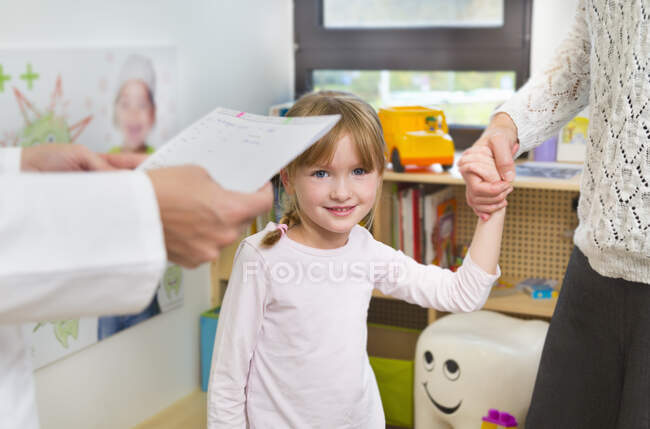 Girl holding hands with mother at dentists — Stock Photo