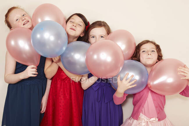 Portrait of four girls holding balloons — Stock Photo