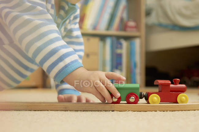 Baby boy playing with train set — Stock Photo