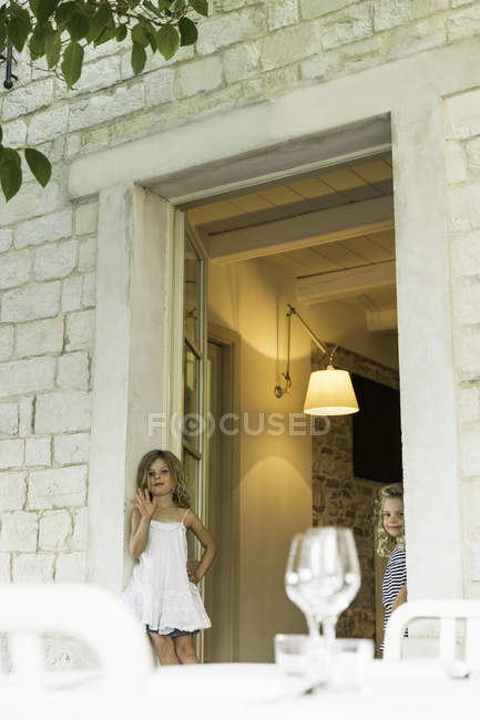 Kleine blonde Mädchen stehen vor Tür von Ferienhaus — Stockfoto