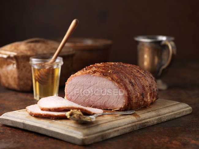 Honey and wholegrain mustard gammon on chopping board — Stock Photo
