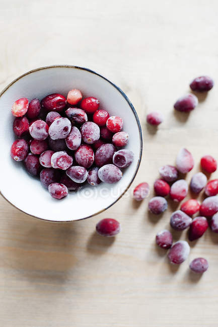 Zuckerbeschichtete rote Beeren in Schüssel und auf dem Tisch — Stockfoto