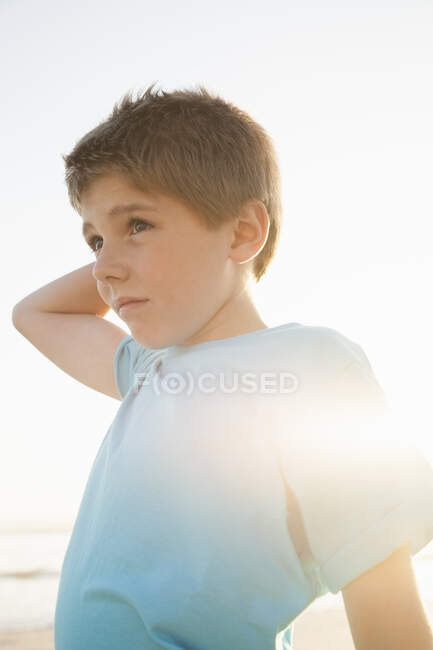 Junge mit Hand auf dem Kopf schaut weg — Stockfoto