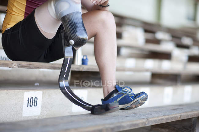 Sprinter seduta con gamba protesica su — Foto stock
