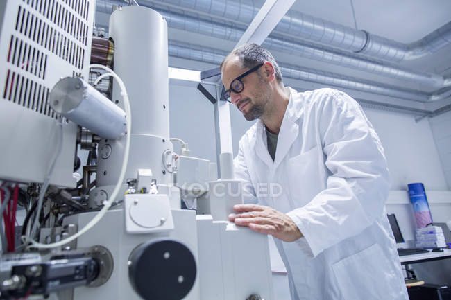 Lab assistant working on professional microscope — Stock Photo