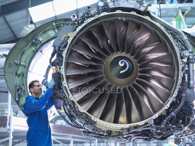 Ingeniero que trabaja en el motor de aeronaves en fábrica de mantenimiento de aeronaves - foto de stock
