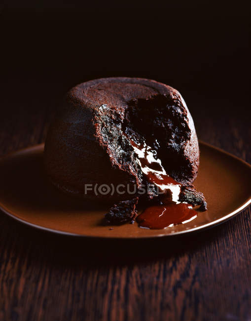 Budino di cioccolato sul piatto trasudando salsa di cioccolato — Foto stock