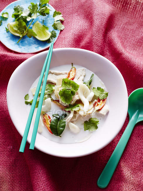 Top view of coconut milk soup in bowl with chopsticks and spoon — Stock Photo