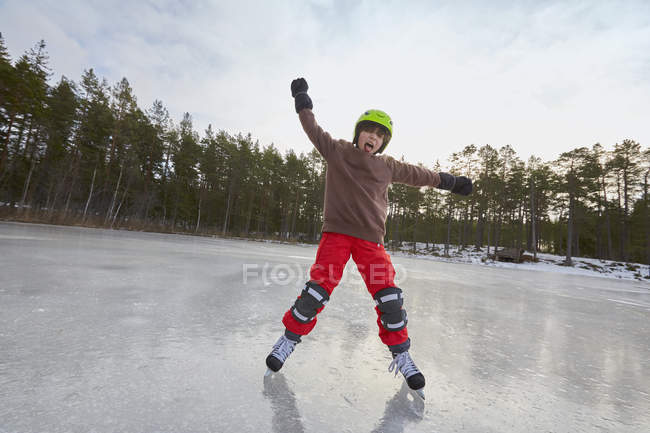 Niño balanceándose mientras patina sobre hielo en el lago congelado, Gavle, Suecia - foto de stock