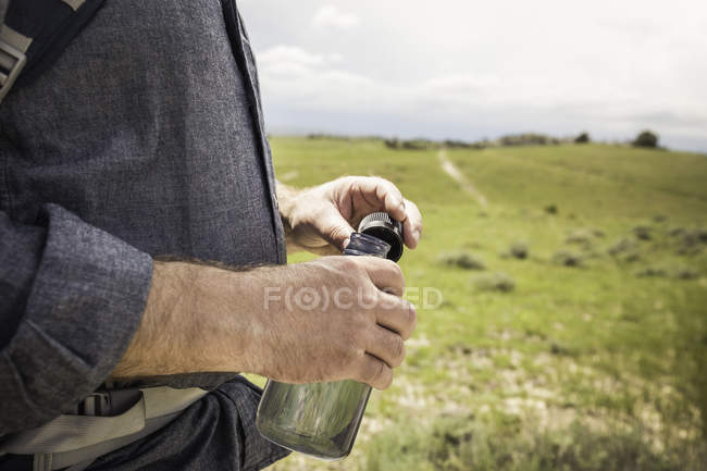 Cropped close up of male hikers hand holding water bottle, Cody, Wyoming, États-Unis — Photo de stock