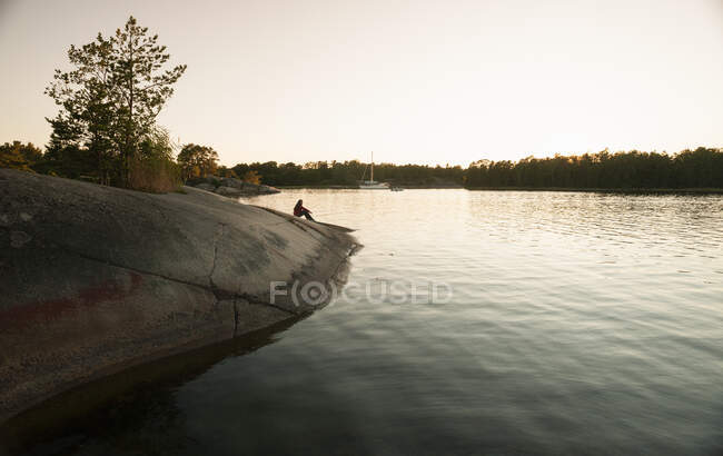 Силуэт человека на берегу реки — стоковое фото
