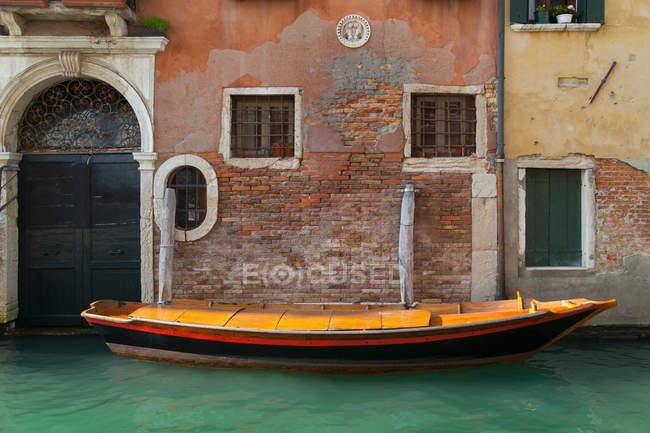 Barco de remos y edificios en canal urbano - foto de stock