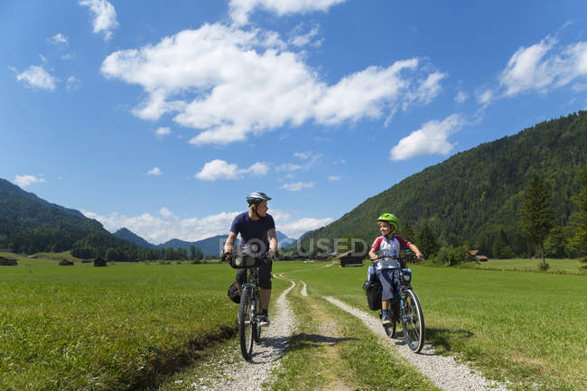 Vélo père et fils à travers Jachenau, Bavière, Allemagne — Photo de stock