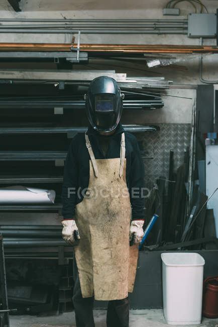 Портрет металлиста в сварочной маске в кузнице — стоковое фото