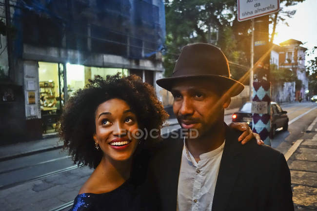 Couple debout ensemble en milieu urbain, souriant — Photo de stock