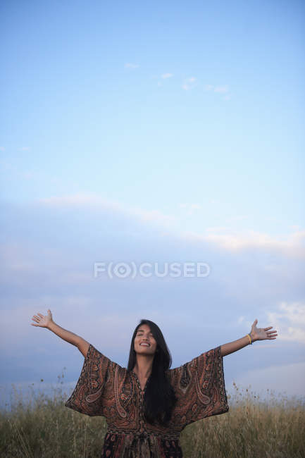 Женщина, наслаждающаяся свежим воздухом с распростертыми объятиями — стоковое фото