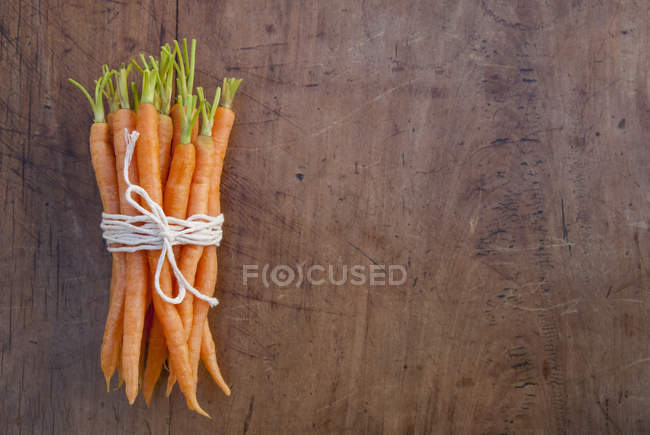 Bunch of carrots tied with string, still life — Stock Photo