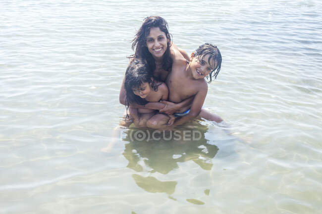Porträt einer Mutter und zweier Kinder im Meer — Stockfoto