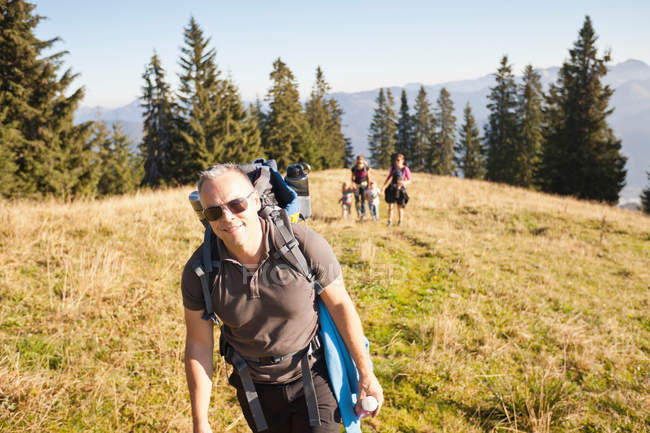 Чоловік пішохідний з пакетом на трав'янистих схилах пагорба — стокове фото