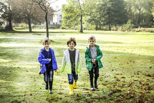 Три мальчика, на улице, ходят по полю — стоковое фото