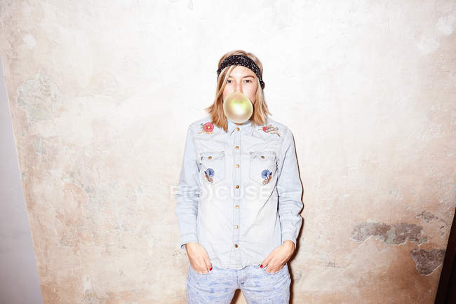 Studio colpo di giovane donna soffiando giallo bolla gomma da masticare bolla — Foto stock