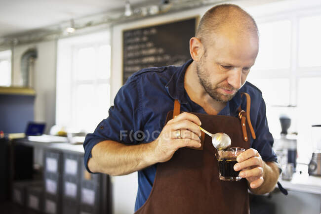 Homme barista en remuant verre de café dans le café bar — Photo de stock