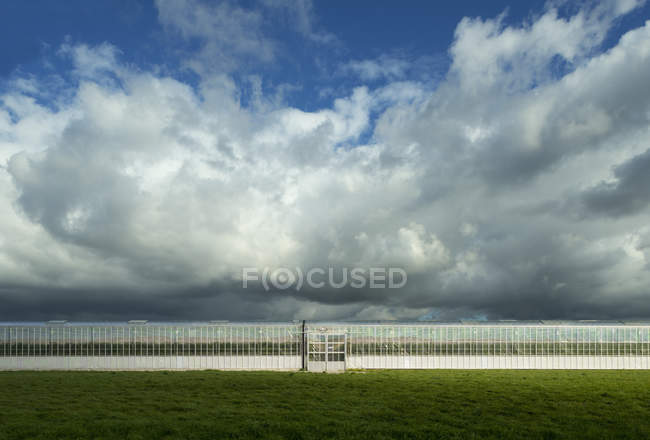 Облака над коммерческой теплицей, S Gravenpolder, Зеландия, Нидерланды — стоковое фото