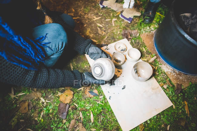 Vista ad alto angolo di qualità giovane donna controllo vasi di argilla rimossi dal fuoco — Foto stock