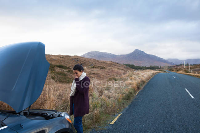 Woman by stalled vehicle at roadside, Connemara, Ireland — Stock Photo