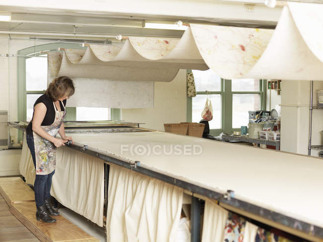 Femme travaillant par séchage dans un atelier textile d'impression manuelle — Photo de stock