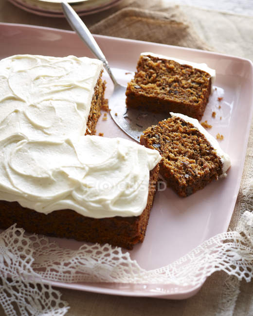 Top view of carrot cake with frosted icing on pink tray — Stock Photo