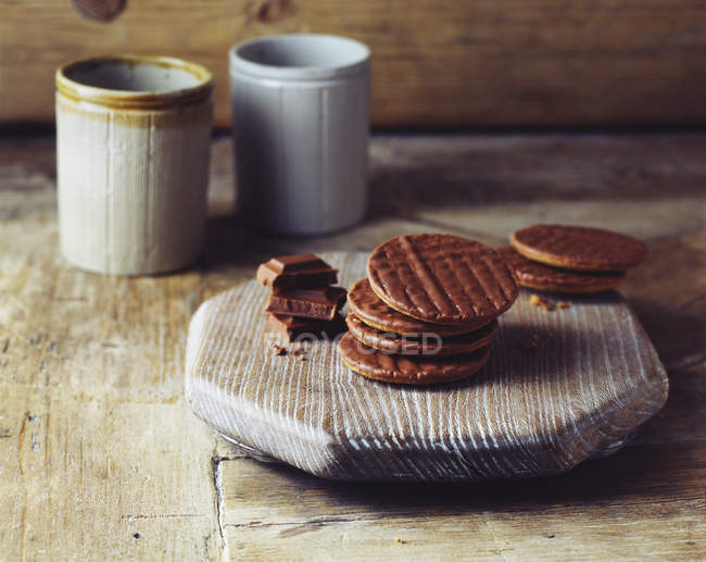 Chocolate digestive biscuits on vintage wooden cutting board — Stock Photo
