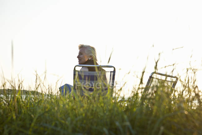 Старша жінка розслабляється на пляжі — стокове фото
