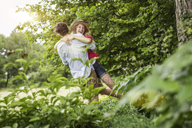 Junges Paar umarmt und lacht im Garten — Stockfoto