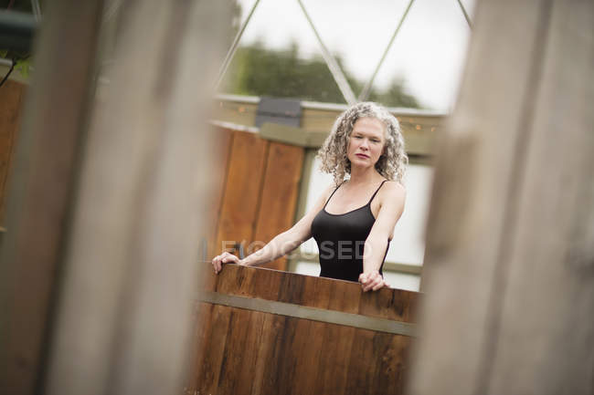 Mature woman standing in hot tub at eco retreat — Stock Photo