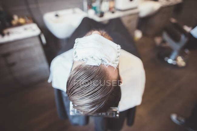 Vista trasera del cliente en la peluquería con ojos de cubierta de tela - foto de stock