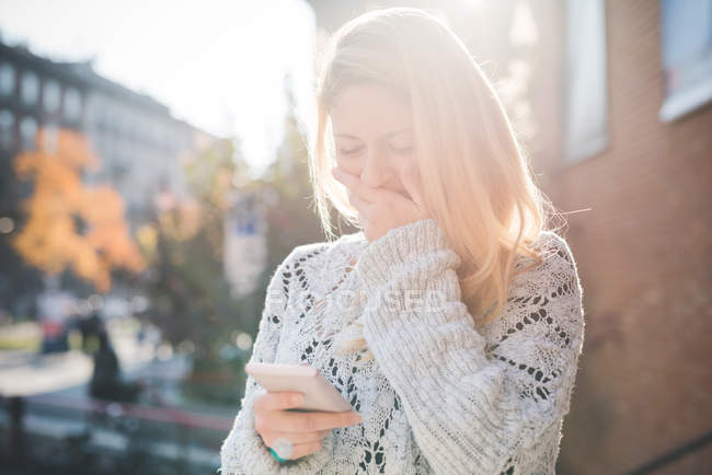 Woman amused with message on smartphone — Stock Photo