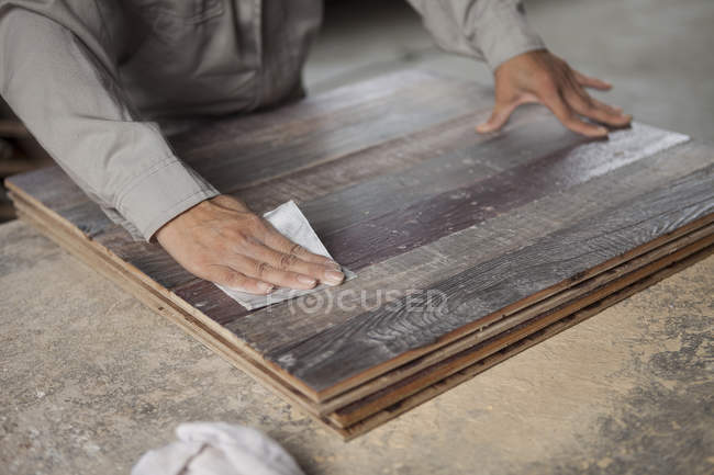 Плотник сглаживание поверхности деревянной доски с наждачной бумагой на заводе, Цзянсу, Китай — стоковое фото